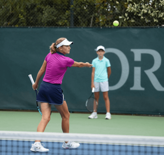 Junior tennis coach working with an under-14 player during a training session in Spain
